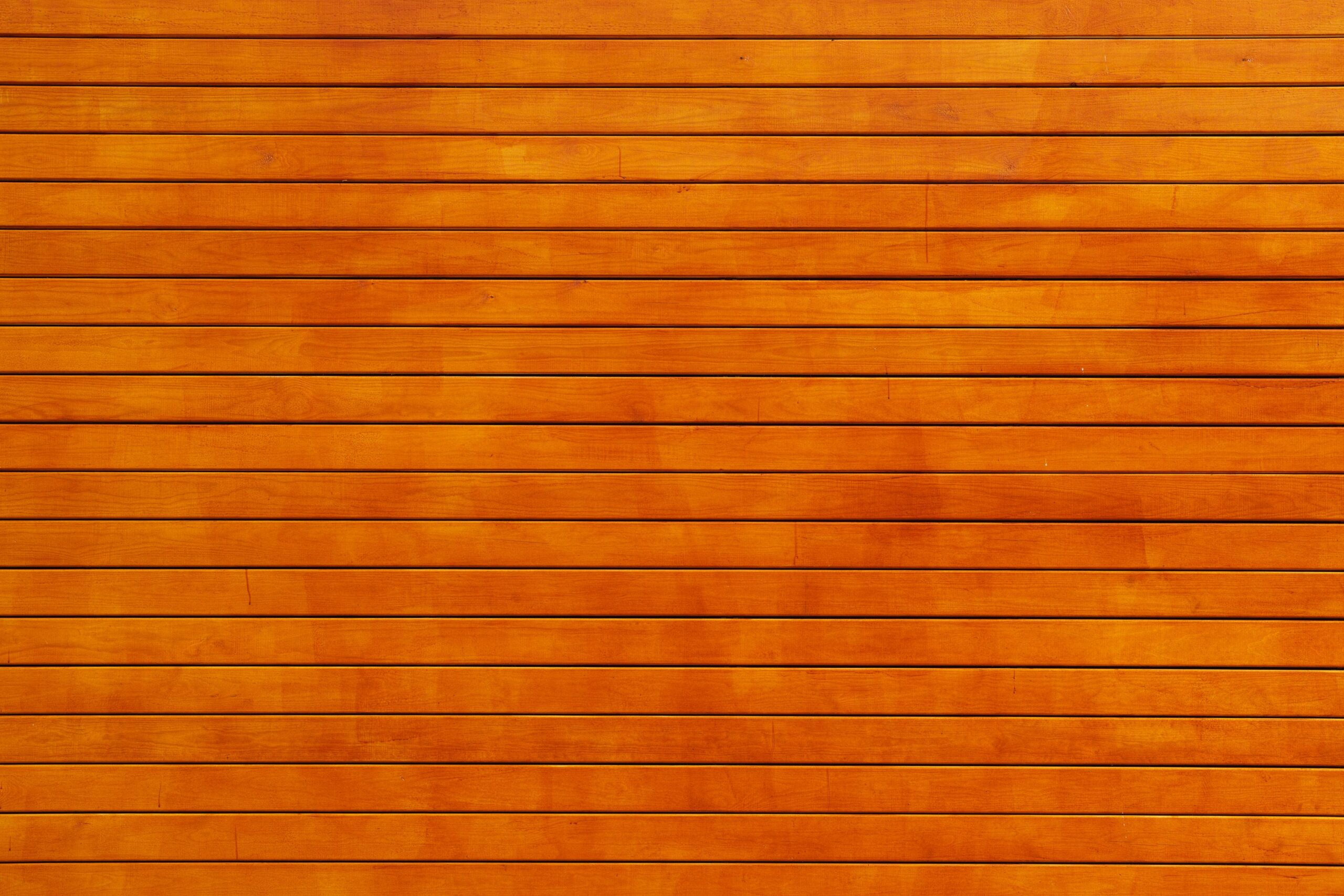 Close-up of a vibrant orange wooden wall texture, ideal for backgrounds.